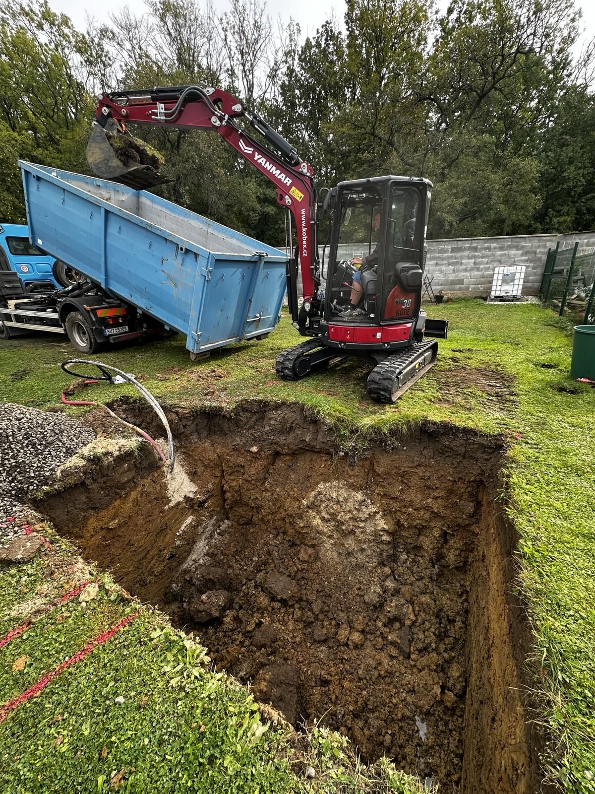 Bagr nakládá kontejner